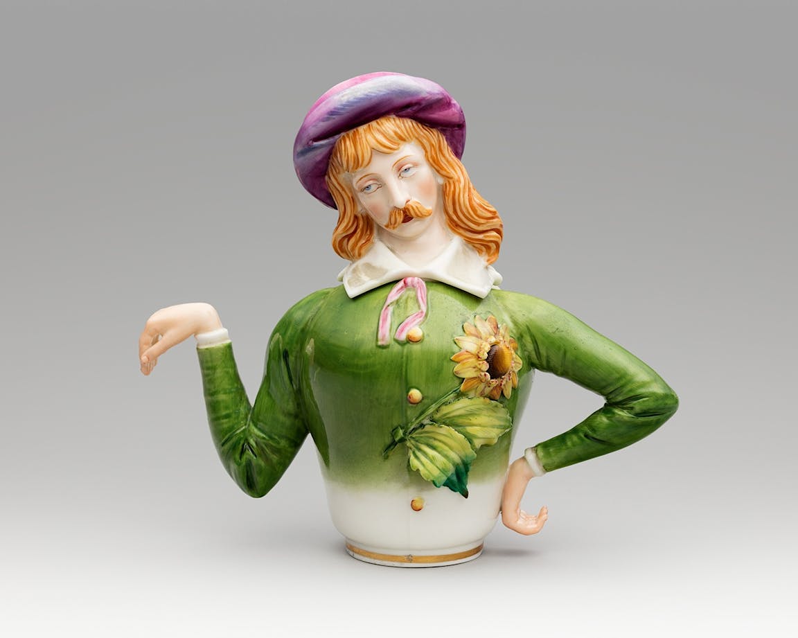A sculpture of the torso of a man with long red hair and a moustache.